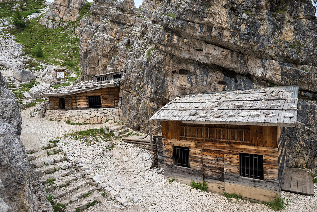 Two small, wooden huts with a gravel trail in front