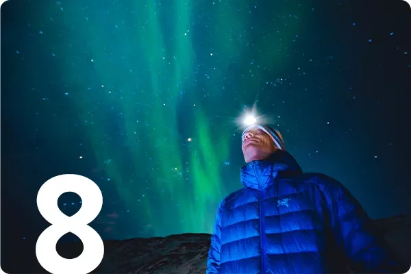 text:8: image: man with headlamp looks at the northern lights