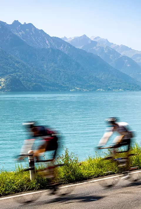 Bikers riding next to a lake in the Swiss Alps