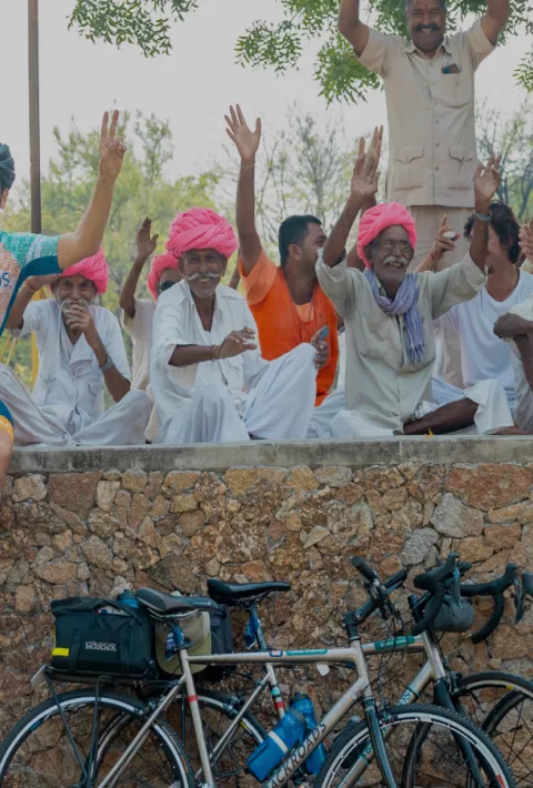 Backroads employees and posing on a wall with a community on India Staff Ride