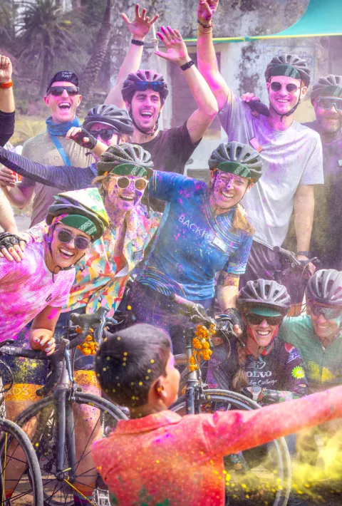 Group of people with bikes being splattered with powder paint