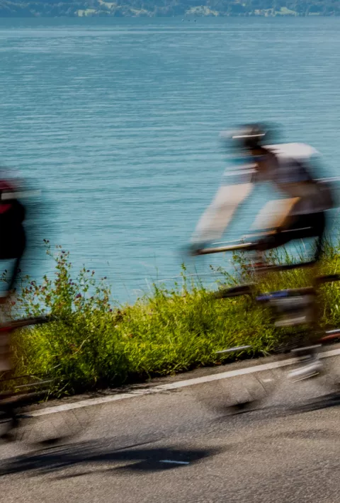 blurry photo of cyclists by the water