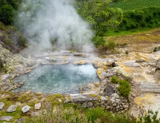 Natural geyser of boiling mineral water and evaporation, located at side of Furnas town on Sao Miguel island of Azores, Portugal. 