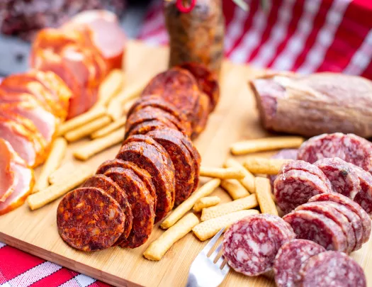 Snack board with cured meats and crackers.