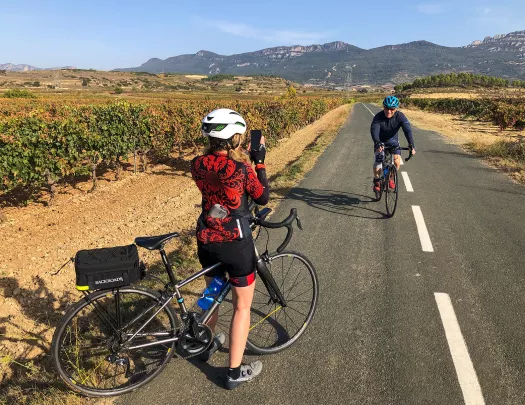 Backroads Guest Taking the Photo of Another Backroads Guest Biking Through a Vineyard