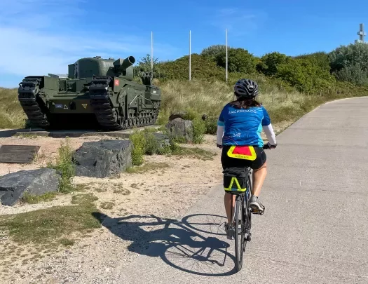 Backroads Guest Biking Past Army tank