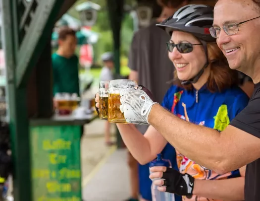 Two bikers saying cheers with mugs of beer.