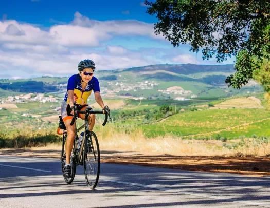 Biker riding on a road near the Douro River.
