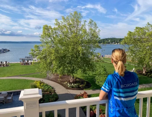 Guest standing on porch, looking out towards a large body of water.