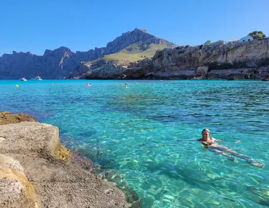 Person swimming in clear blue water in Mallorca.
