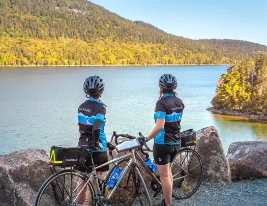 Two guests with bikes overlooking large body of water.