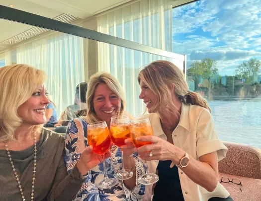 Guests with aperol spritzes raising a glass
