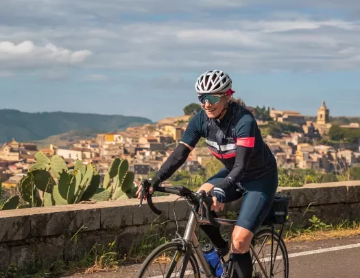 Guest cycling past mountaintop city.