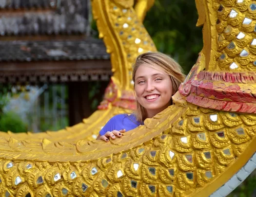 Guest posing with a dragon statue in Thailand