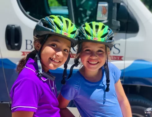 Two young guests in bike gear in front of BR van.