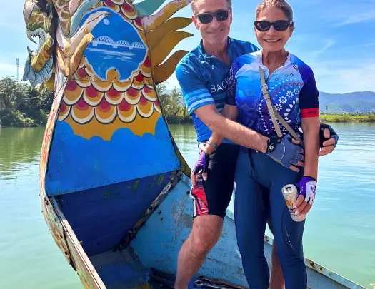 Two Backroads guests posing on a dragon boat in Vietnam
