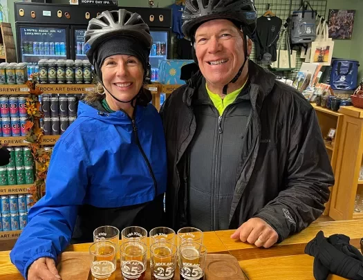 Two guests in store, posing with beer flight.