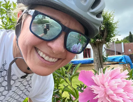 Woman posing with a bright pink flower