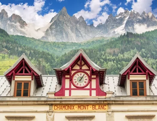 Train station clock at Chamonix Mont-Blanc, mountain in distance.