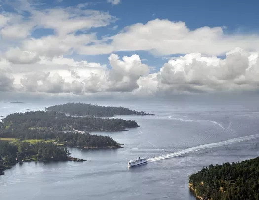 Boat traveling between islands - big white puffy clouds in a blue sky