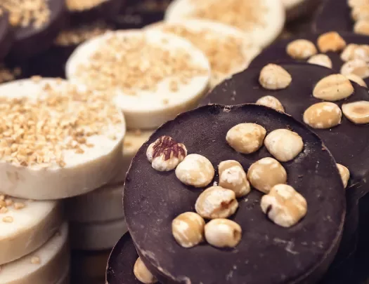Close-up of chocolate pucks, nuts on top.