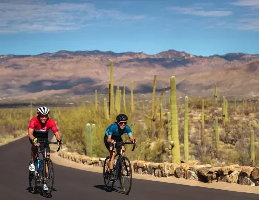 Biker wearing red, biker wearing blue, on road in AZ