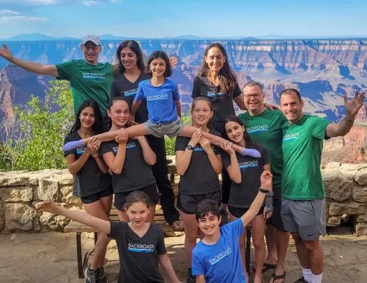 Group of guests posing in front of large Grand Canyon vista.