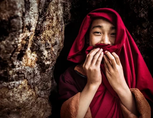 Monk smiling and covering their mouth in Bhutan