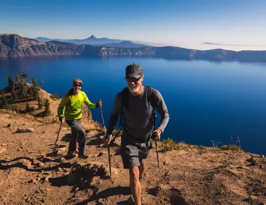 Two guests hiking along the rim of Crater Lake.