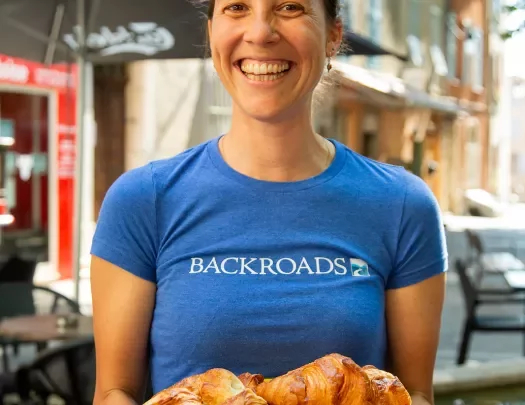 Backroads leader holding plate of croissants. 