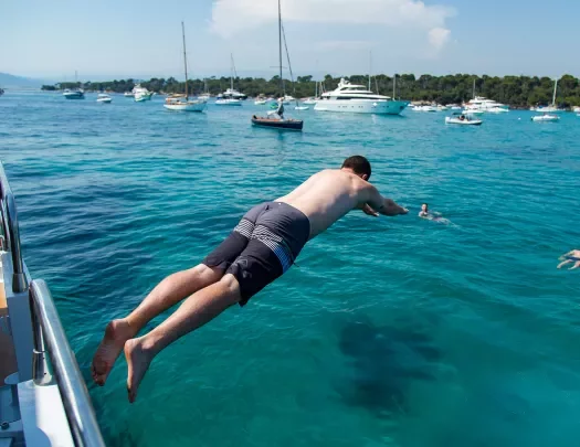 Backroads guest diving into the sea from the side of a boat