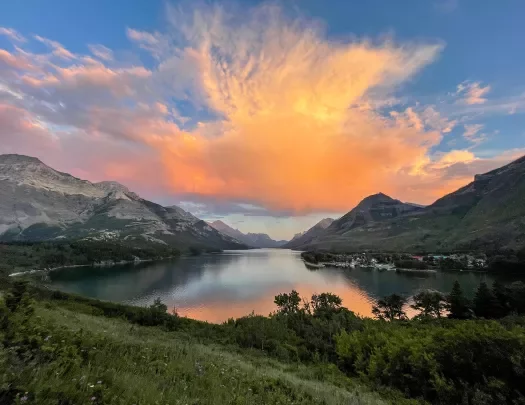 Orange sunset over lake and mountains