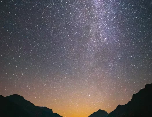 Sunset with eyepopping stars shining over mountains and lake