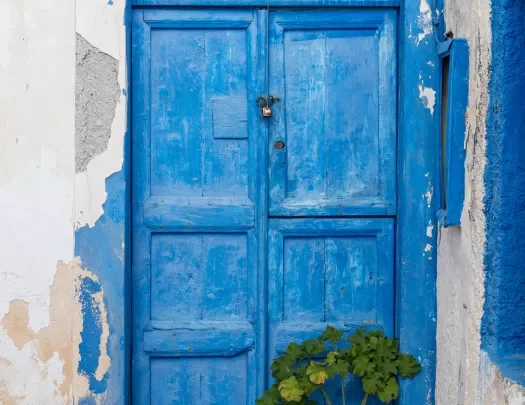 Close-up of blue door on white building.