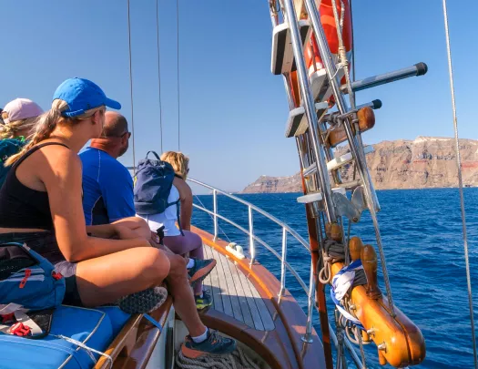 Group of guests sitting on boat, looking out towards ocean.