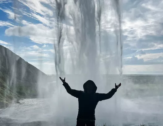 Gust standing under waterfall