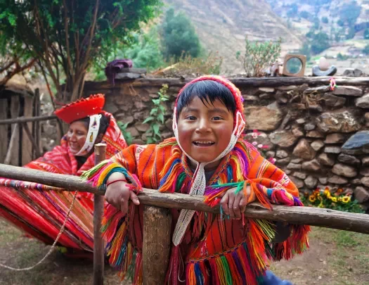 Two locals in colorful garb, one looking at camera, smiling.