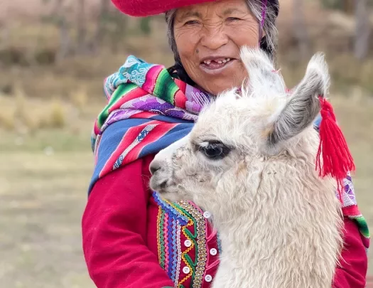 Local woman in colorful garb, baby alpaca.