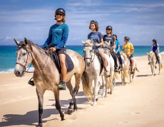 Backroads guests riding horses along the beach in Portugal