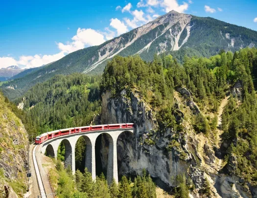 Landwasser viaduct in the Davos mountains near Filisur. Beautiful old stone bridge with a moving train. 