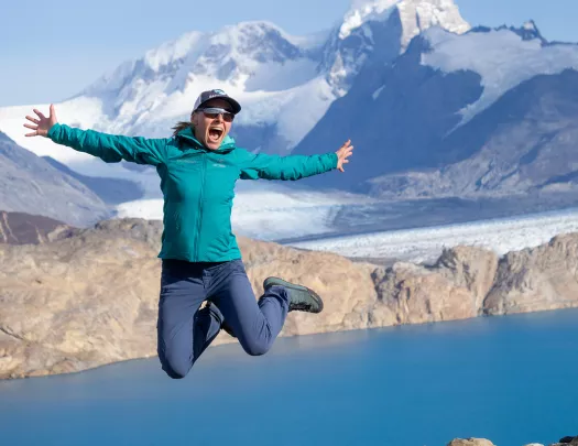 Woman posing for camera, jumping into air.