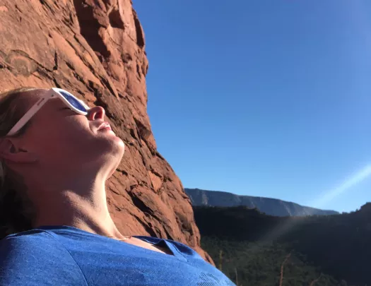 Woman resting on a hike, sunbathing.