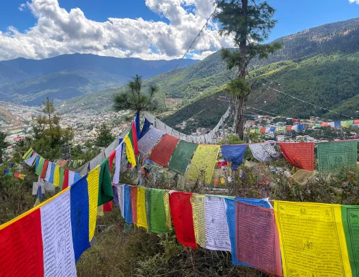 Brightly colored flags strung up above a valley in Bhutan