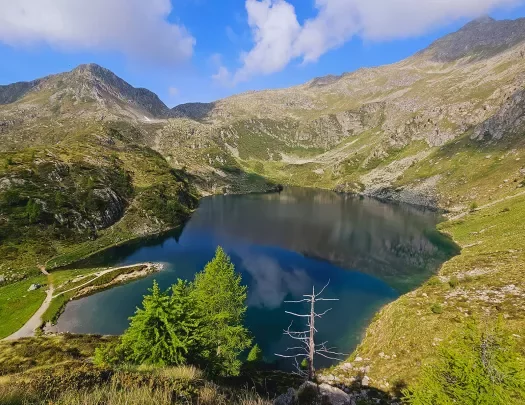 Wide shot of blue lake, ring of mountains all around.