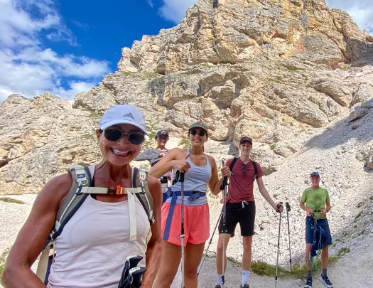 Five guests looking at camera, craggy cliff behind them.