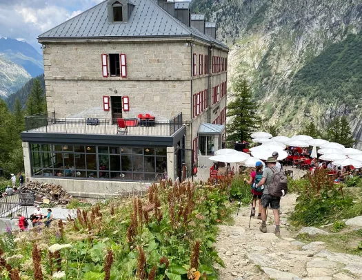 Guests walking towards clifftop restaurant/café. Rocky hillside in background.