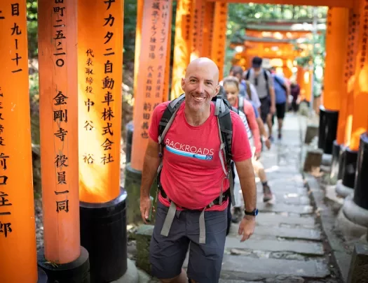 Walking up a hill among orange arches in Japan