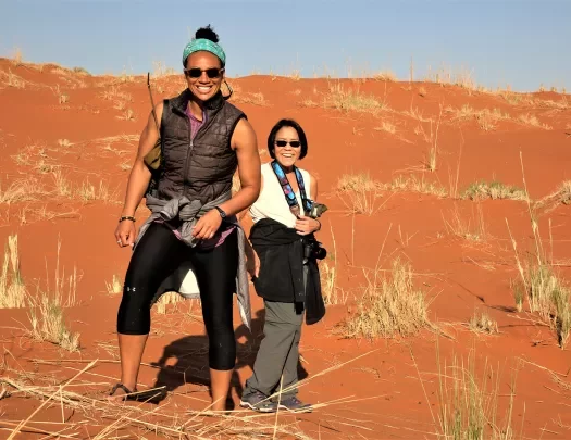 2 women standing in the dunes of Africa