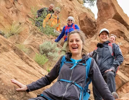 Guests smiling while climbing down boulders