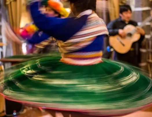 Local dance in colorful dress, spinning quickly.